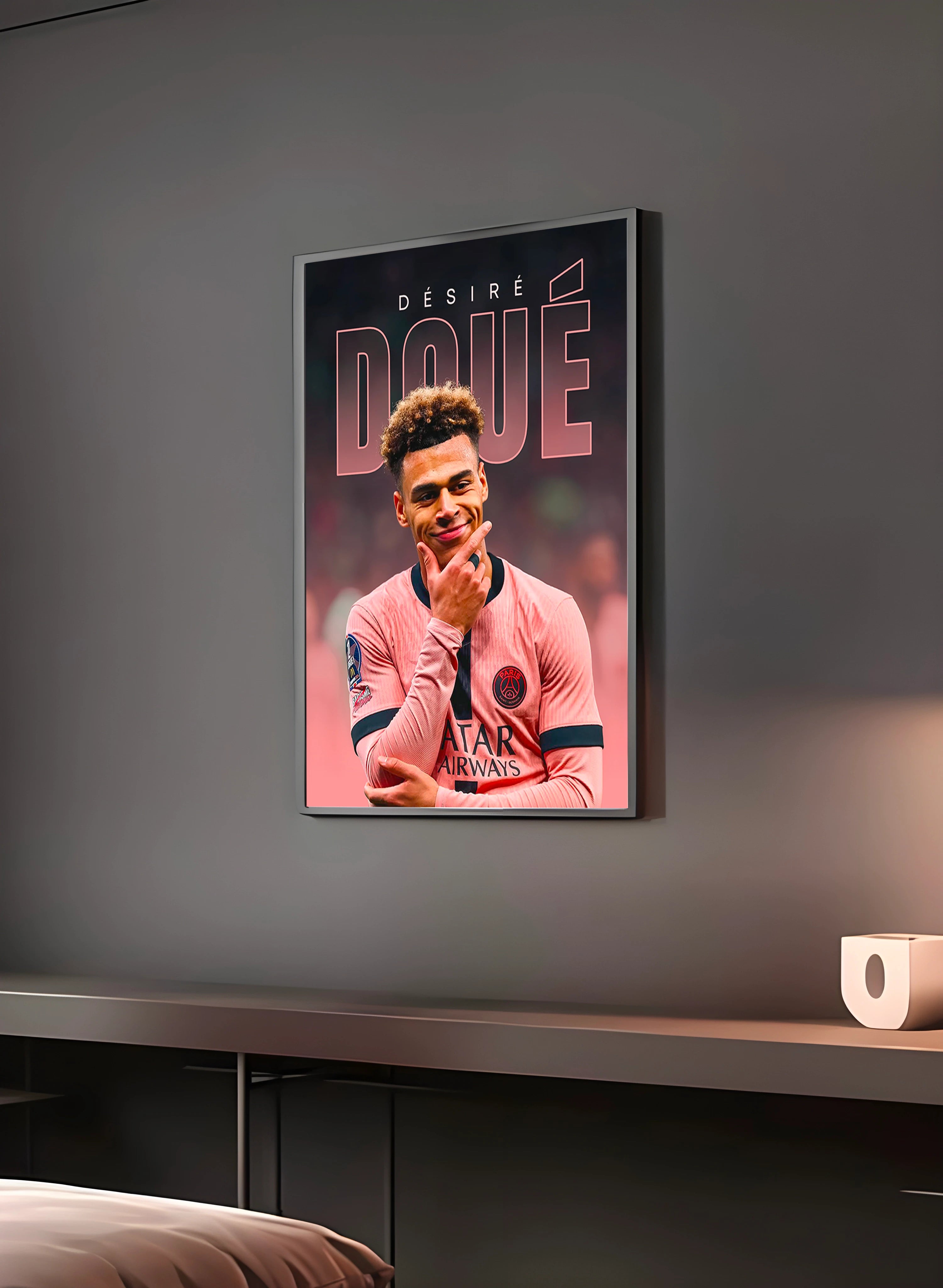 Poster "DÉSIRÉ DOUÉ" en perspective 3/4 – dans un cadre, ambiance déco, ton rose