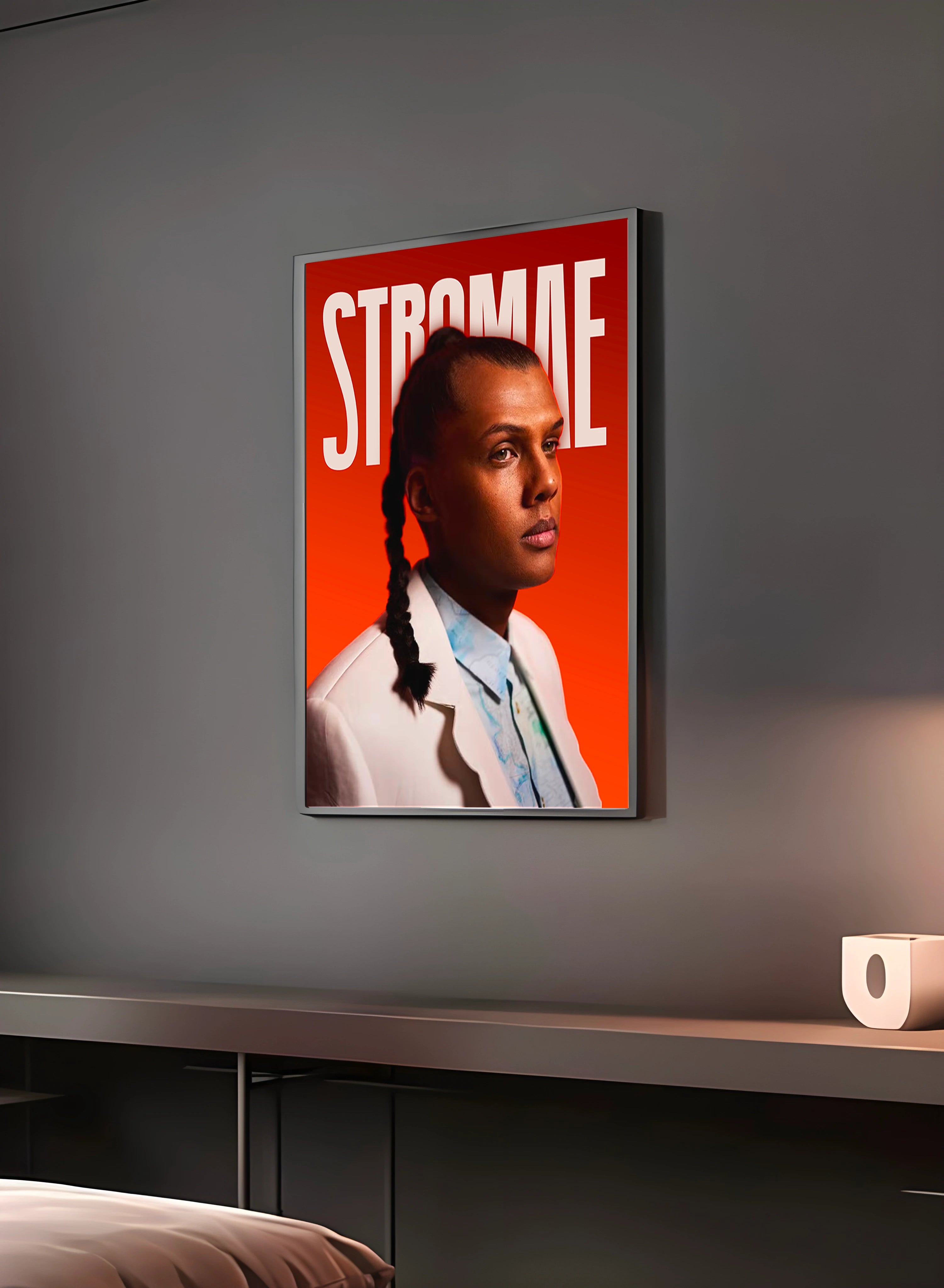Poster "STROMAE" en perspective 3/4 – dans un cadre, ambiance déco, ton orange